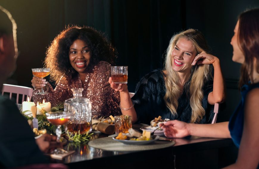 a group of people sitting around a table with food and drinks