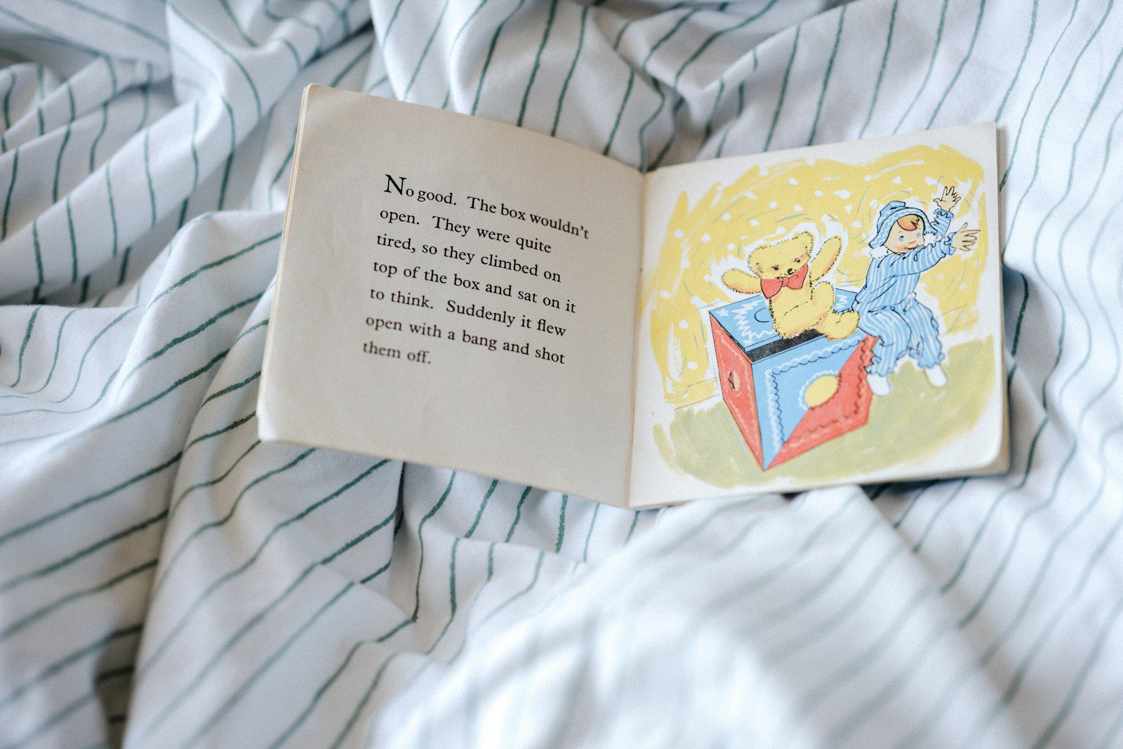 white book on white and blue textile