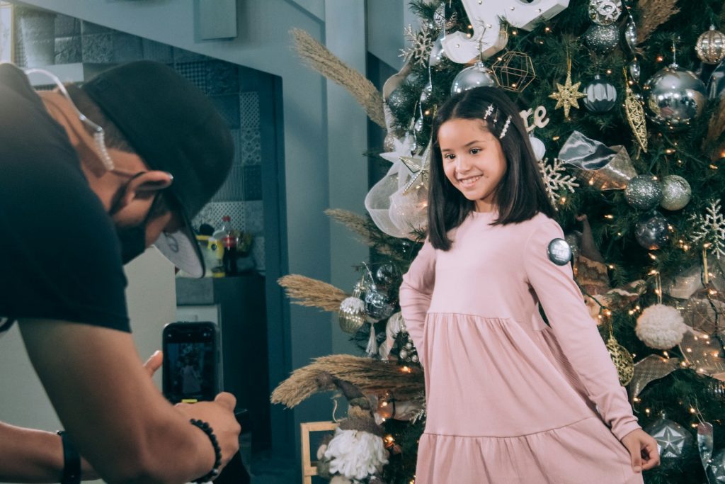 woman in white dress standing beside christmas tree