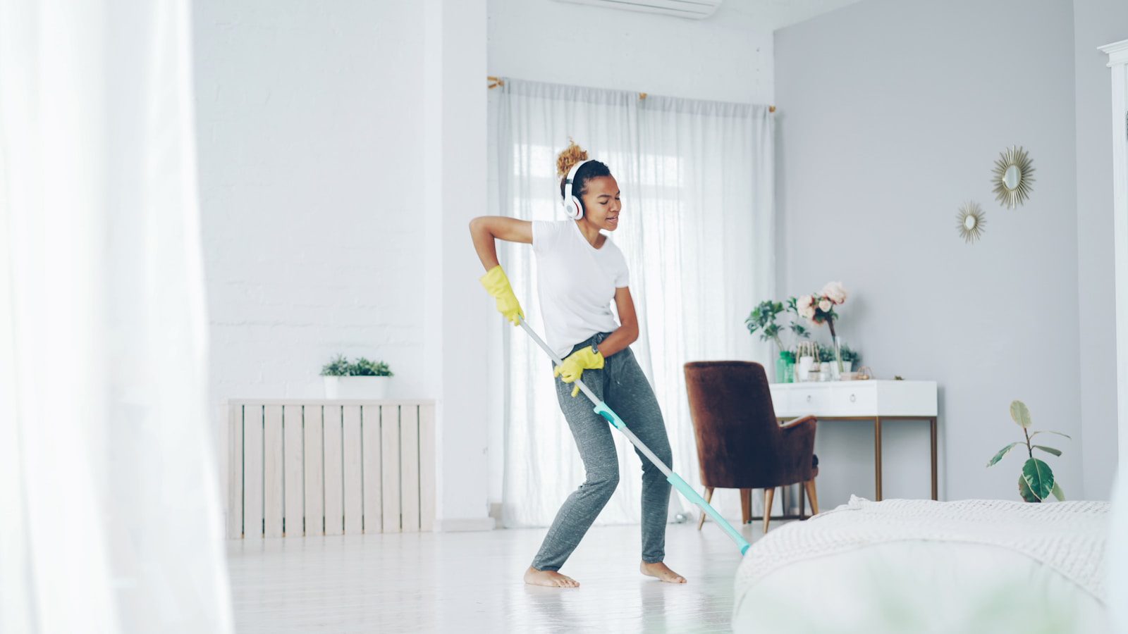 Woman dancing while cleaning with a mop