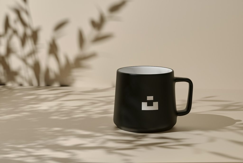 Black mug on a neutral backdrop with shadows.