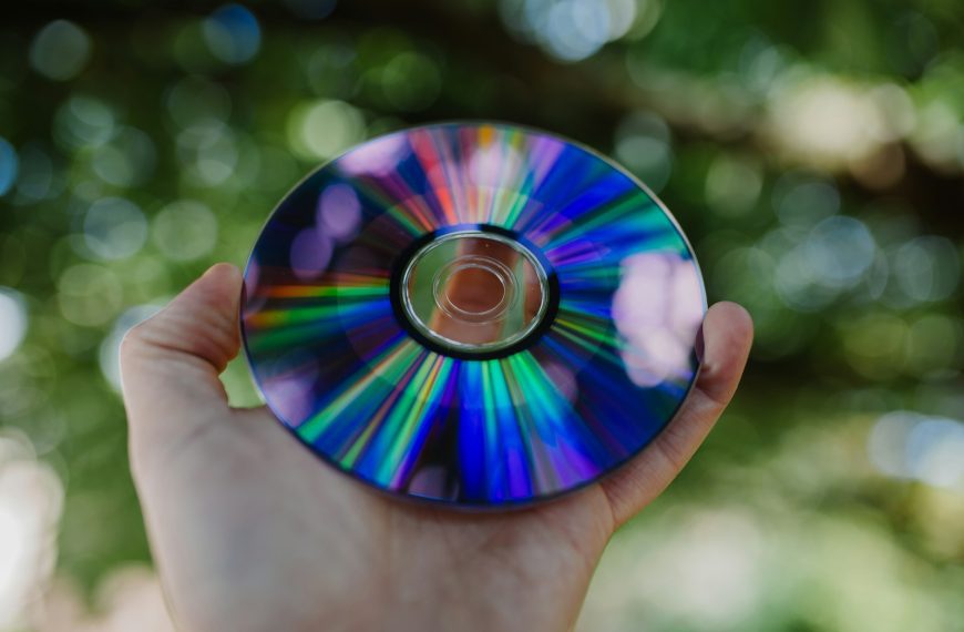 selective focus photography of person holding compact disc