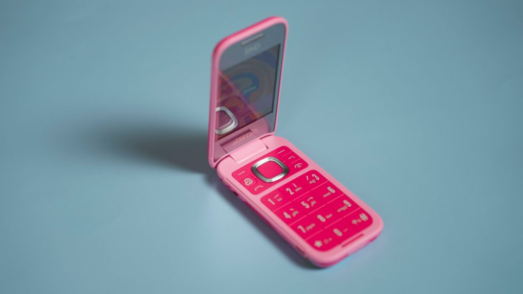 A pink cell phone sitting in a pink case
