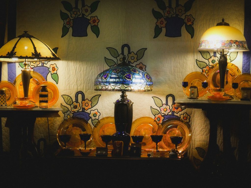Two illuminated lamps on a shelf with plates