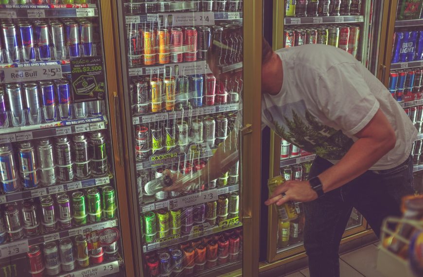man getting can in beverage cooler