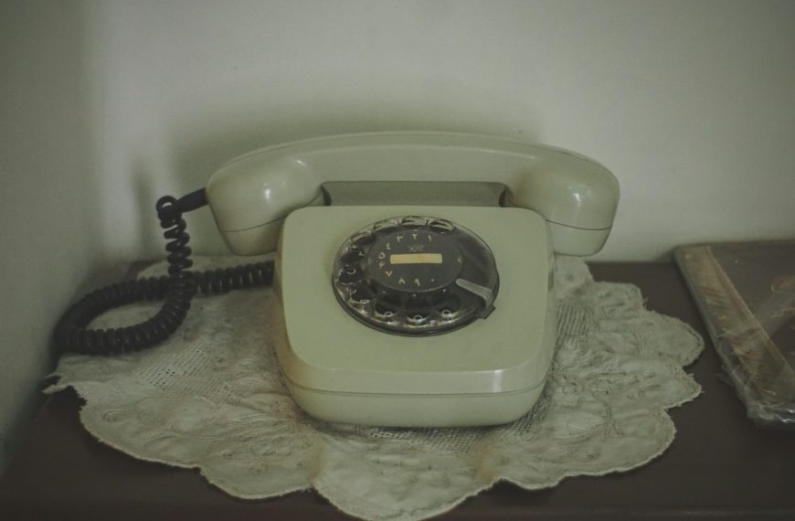 Vintage rotary dial telephone on a doily.