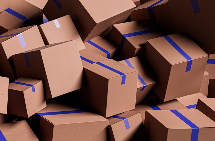 A large pile of brown cardboard boxes with blue tape.