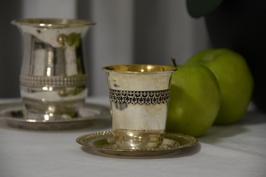 A couple of silver cups sitting on top of a table