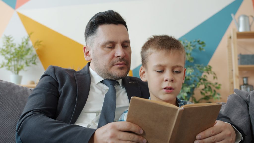 Father and son reading a book together