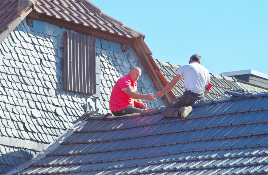 two men working on the roof of a house