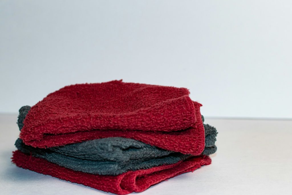 A stack of red and grey towels sitting on top of a table