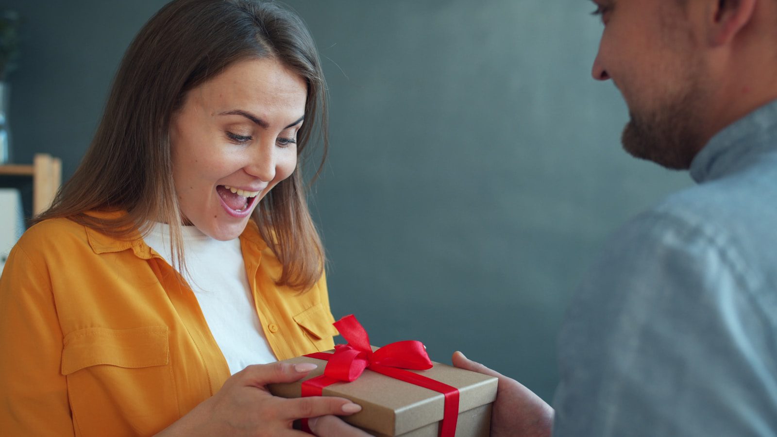 Woman happily receiving a gift from man