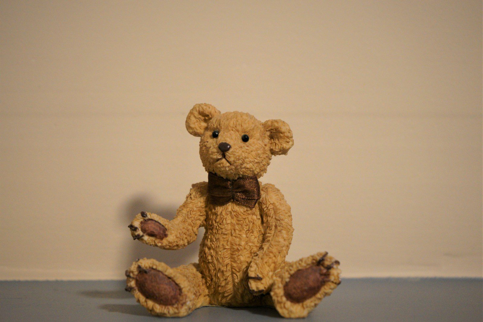a brown teddy bear sitting on the floor