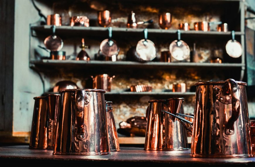 a bunch of copper cups sitting on top of a table