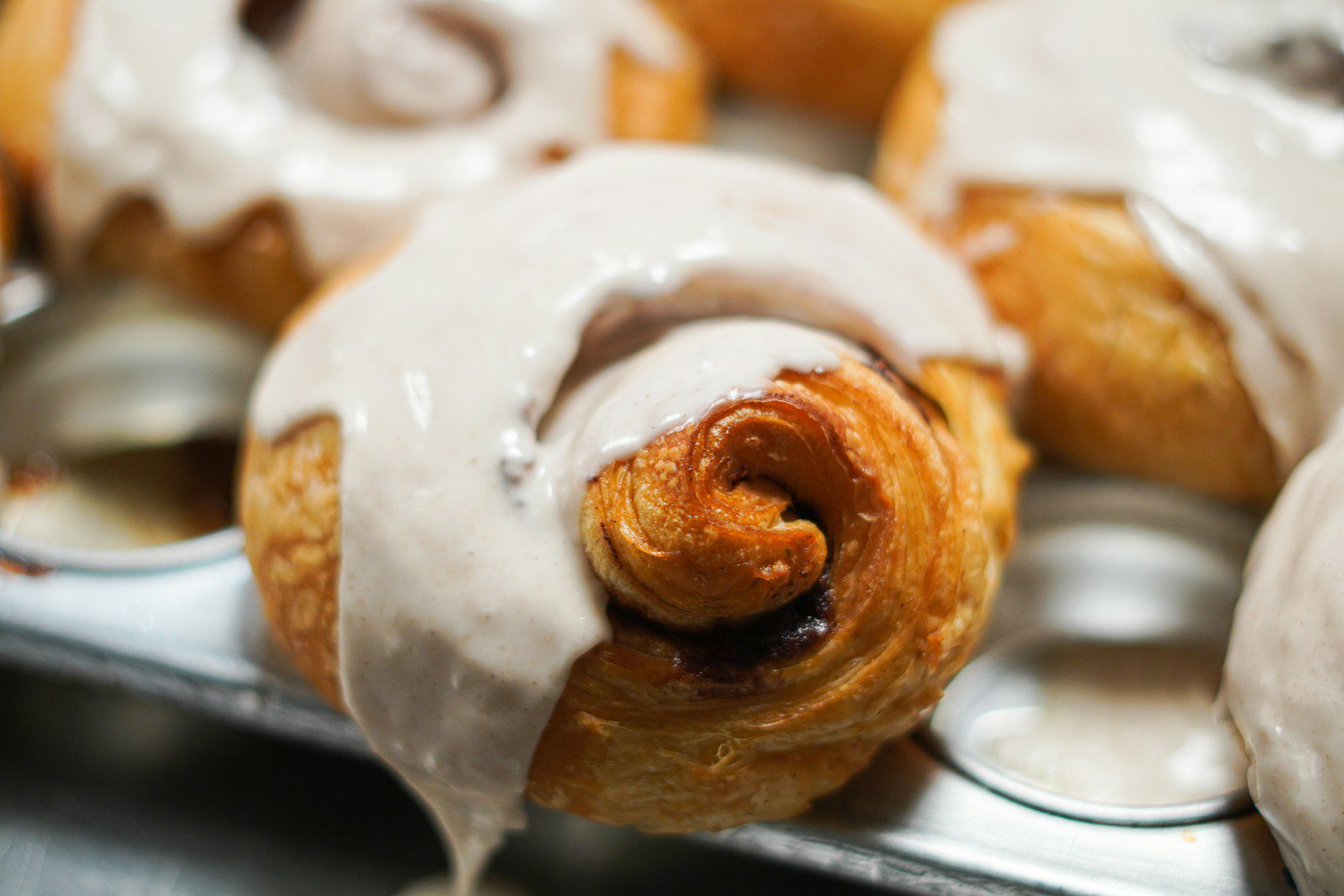 a close up of a tray of doughnuts with icing