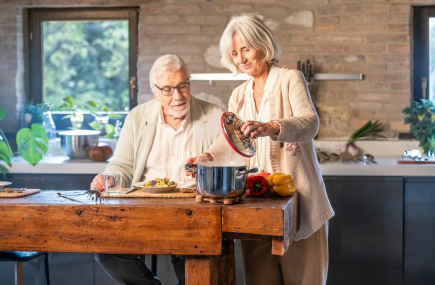 Elderly couple cooking together in a modern kitchen.