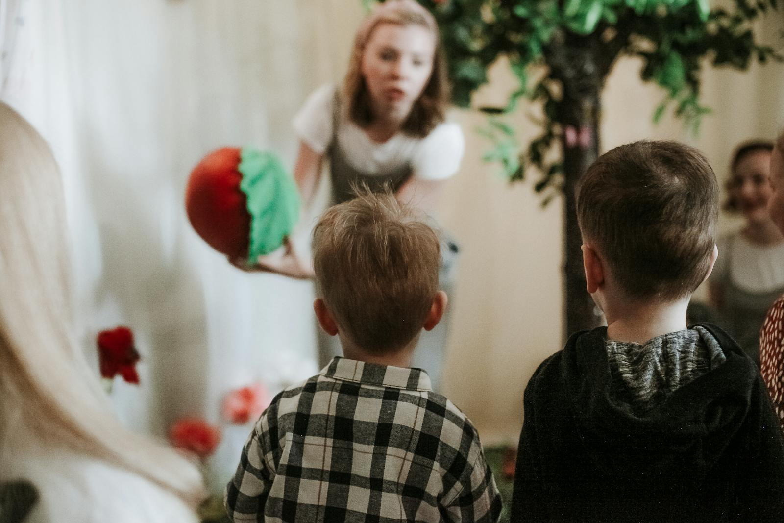 Young children participating in a fun and interactive learning session with a teacher indoors.