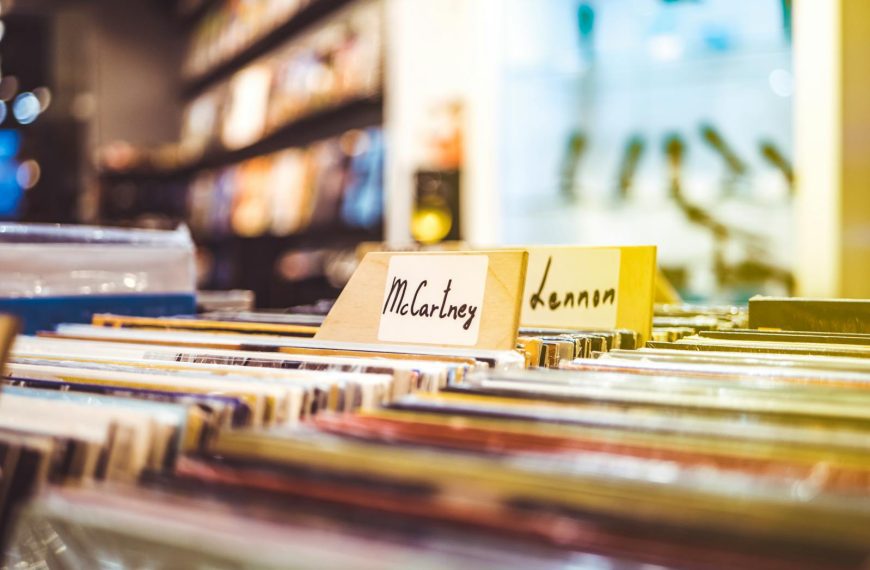 Colorful display of vinyl records in a music store, focusing on McCartney and Lennon sections.