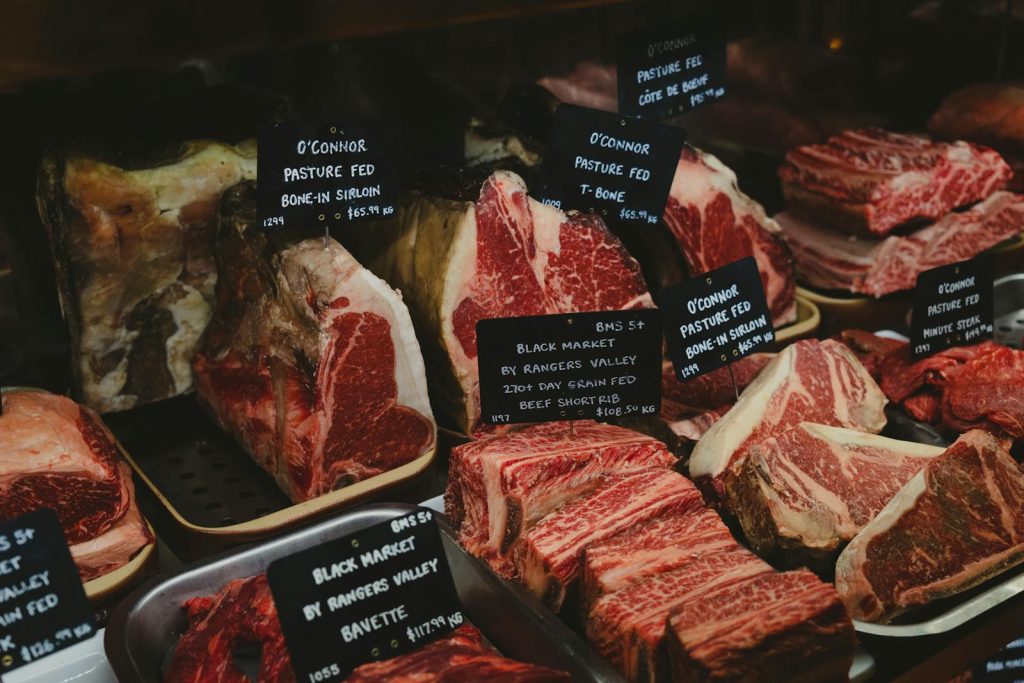 Assorted premium beef cuts with labels showcased in a gourmet market setting.