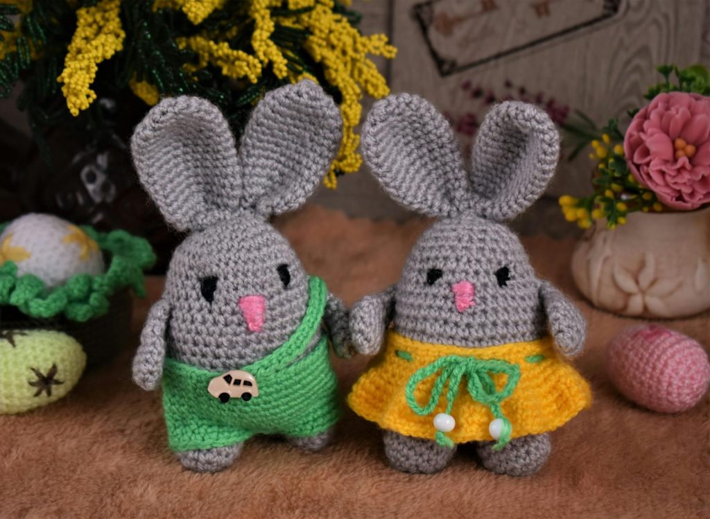 Adorable crocheted bunnies with Easter decorations, perfect for holiday crafting.