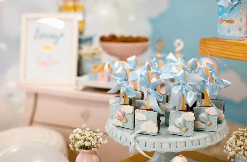 Elegant baby shower dessert table with pastel decorations and sweet treats.