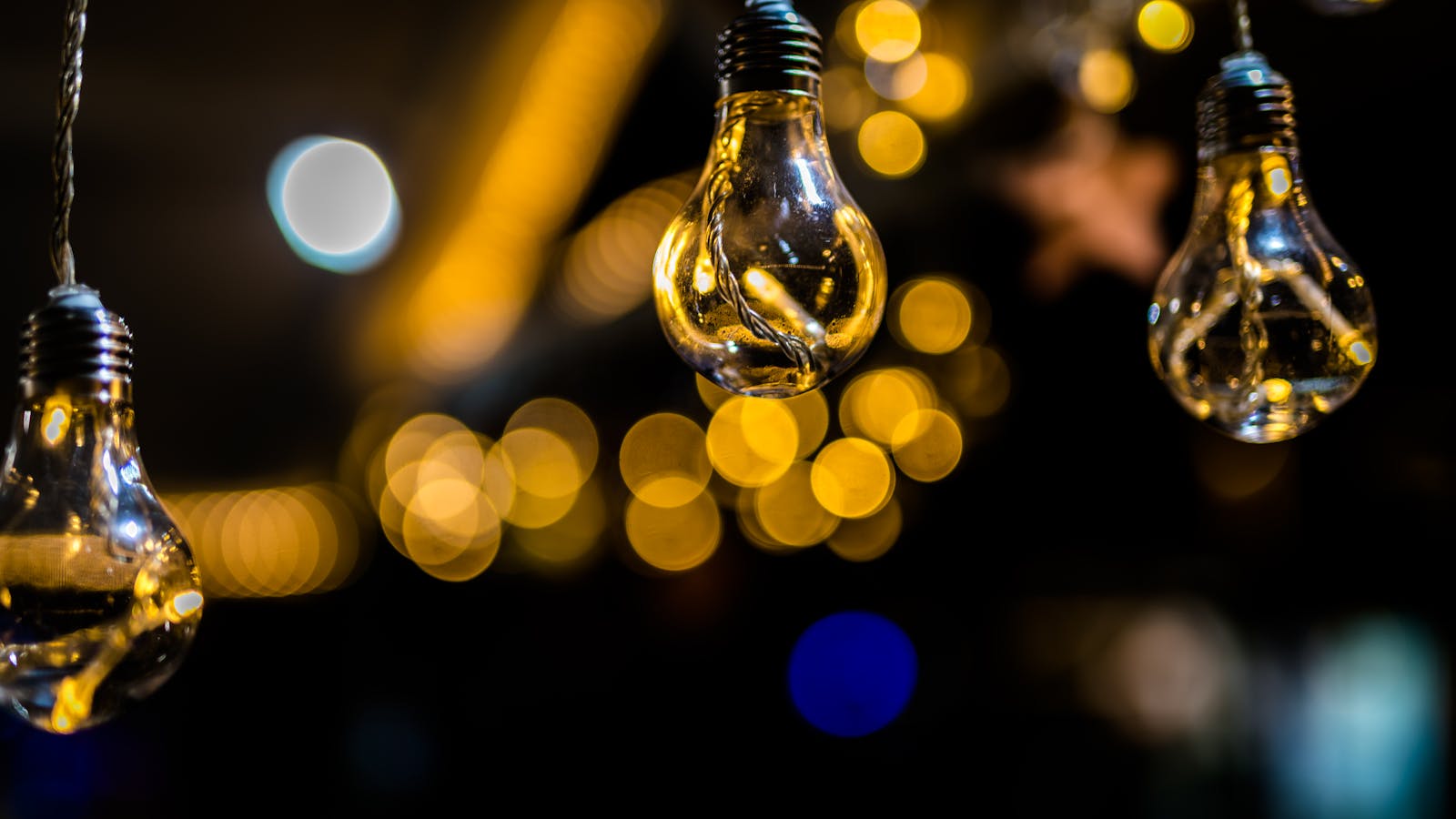 Artistic shot of hanging light bulbs with a beautiful bokeh background effect.