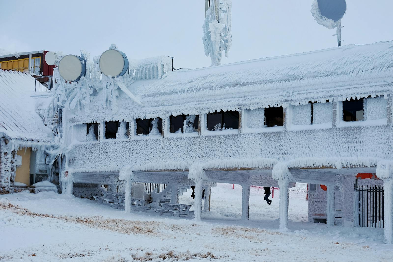 A frozen building covered in thick ice and snow, showcasing extreme winter conditions.