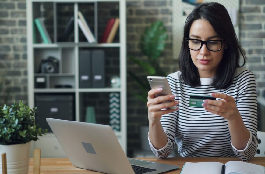 a woman sitting at a table looking at her cell phone