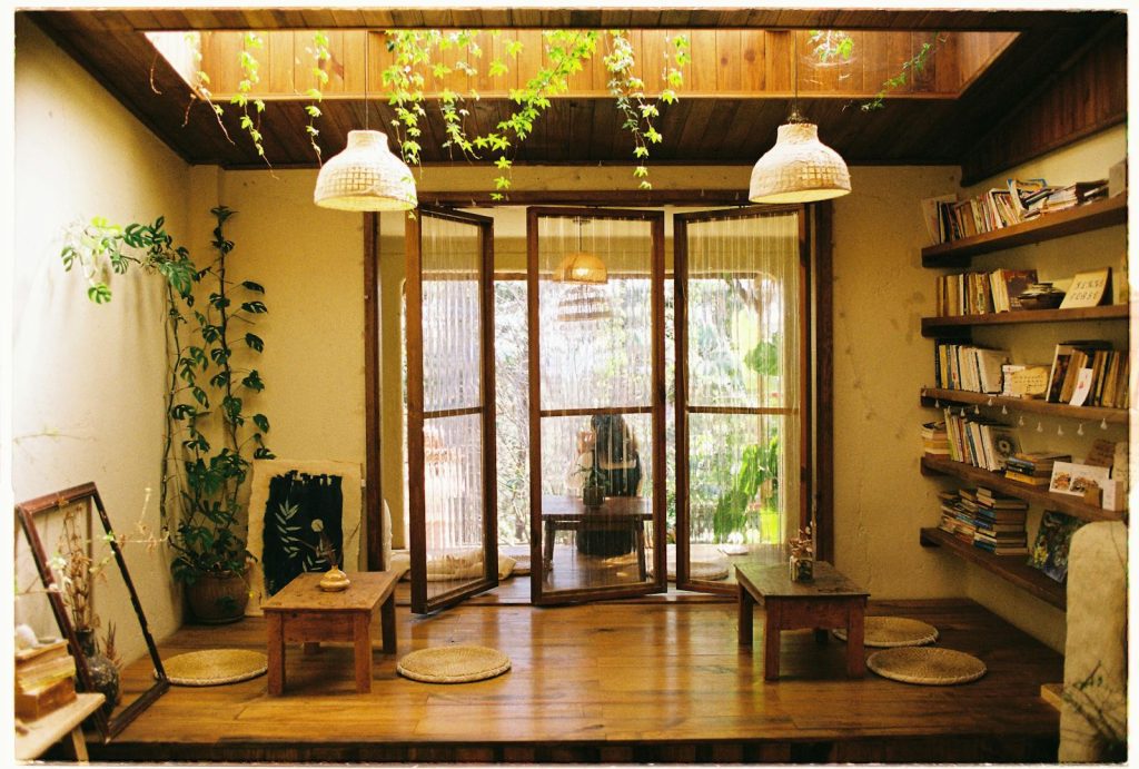 Warm room with wooden decor, bookshelves, and indoor plants.