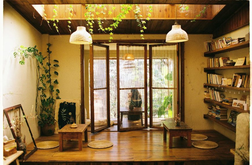Warm room with wooden decor, bookshelves, and indoor plants.