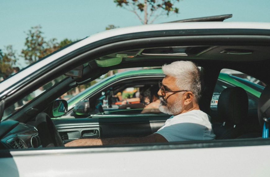 Senior man driving a vintage sports car on a sunny day in İstanbul, Türkiye.