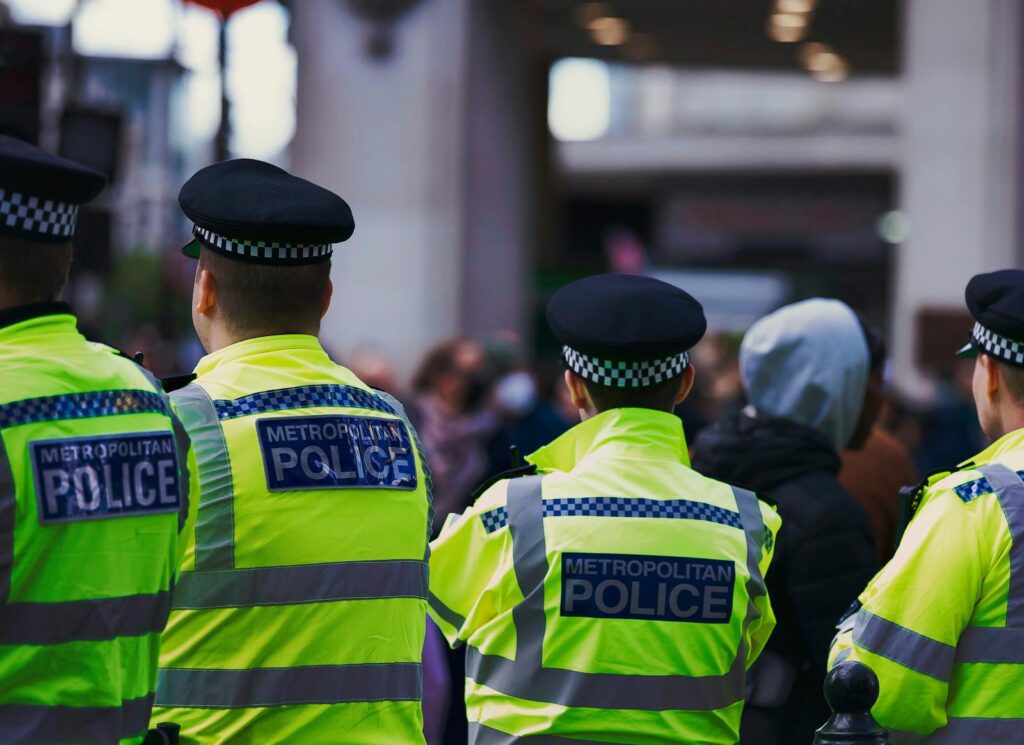 Metropolitan Police officers in high-visibility jackets on patrol in London.