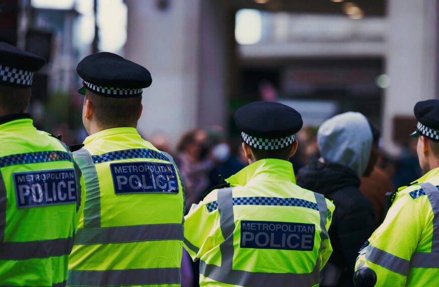 Metropolitan Police officers in high-visibility jackets on patrol in London.