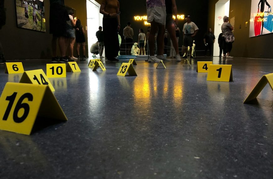 people sitting and standing inside building with numbers on floor