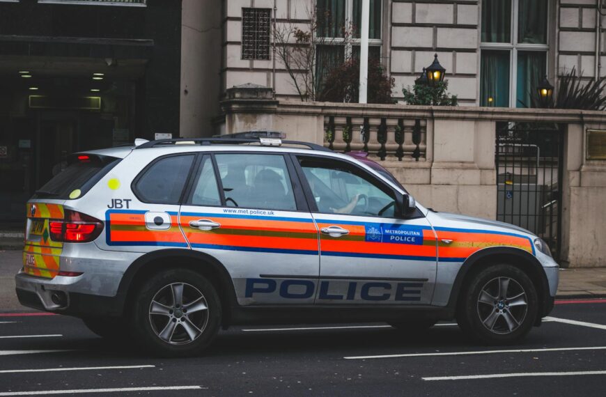 Police vehicle parked on an urban street outside a London building