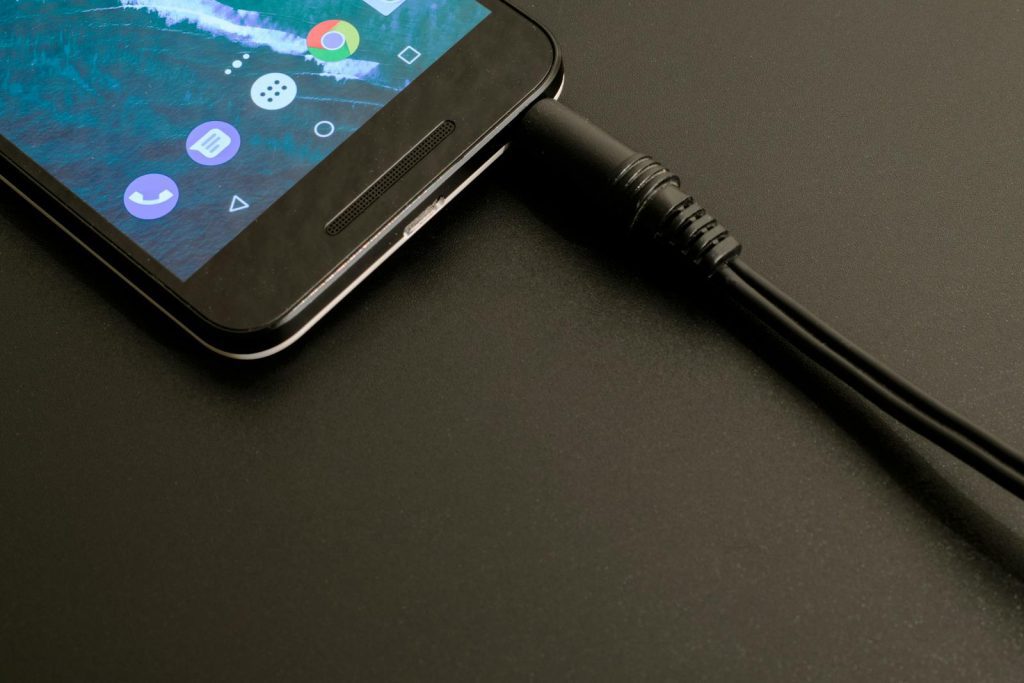 Close-up of a smartphone being charged, displaying a modern interface on a dark backdrop.