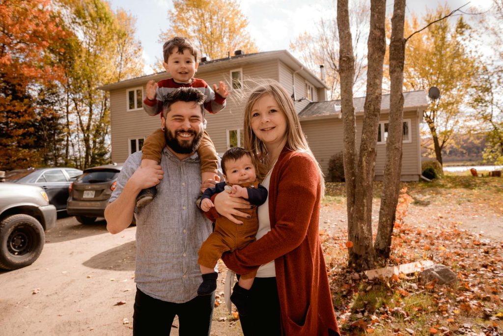 Smiling family of four enjoying a sunny autumn day in their backyard.