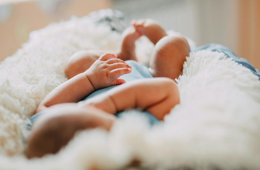 A serene close-up of a sleeping newborn lying on a fluffy blanket indoors.