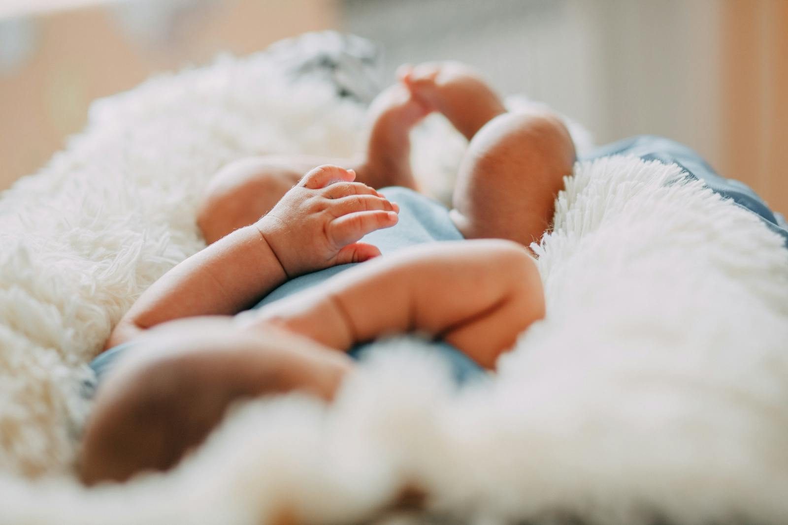A serene close-up of a sleeping newborn lying on a fluffy blanket indoors.