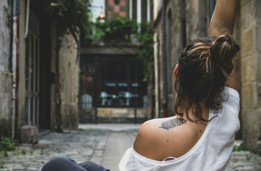 woman in white tank top sitting on concrete bench during daytime