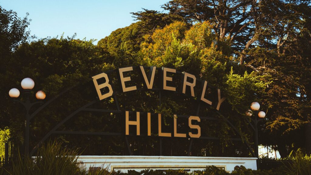 Discover the famous Beverly Hills sign amid lush greenery on a sunny day.