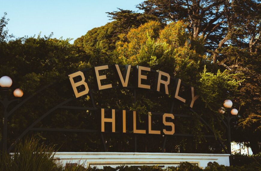 Discover the famous Beverly Hills sign amid lush greenery on a sunny day.