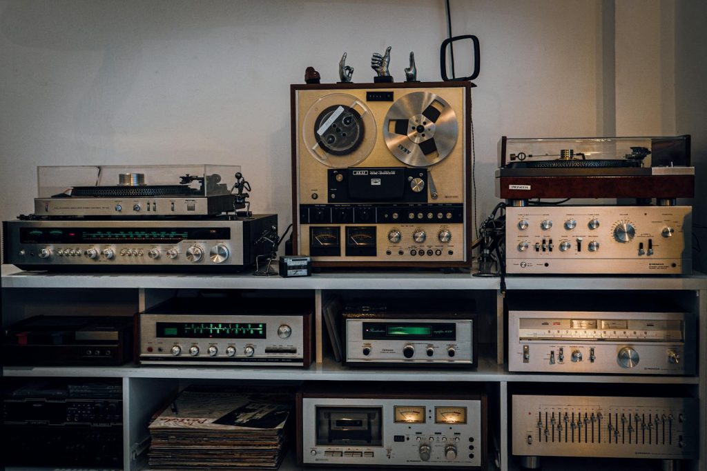 A collection of vintage audio equipment including reel-to-reel, turntables, and amplifiers.