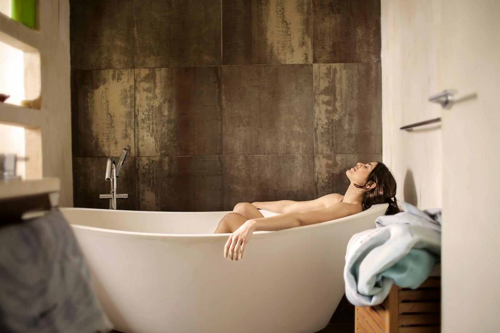 A serene moment of a woman enjoying a peaceful bath in a stylish indoor setting.