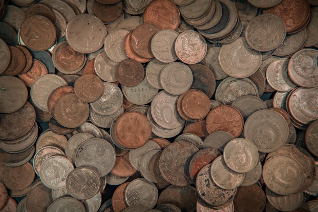 Close-up view of assorted foreign coins in a large mixed pile, perfect for finance-related projects.