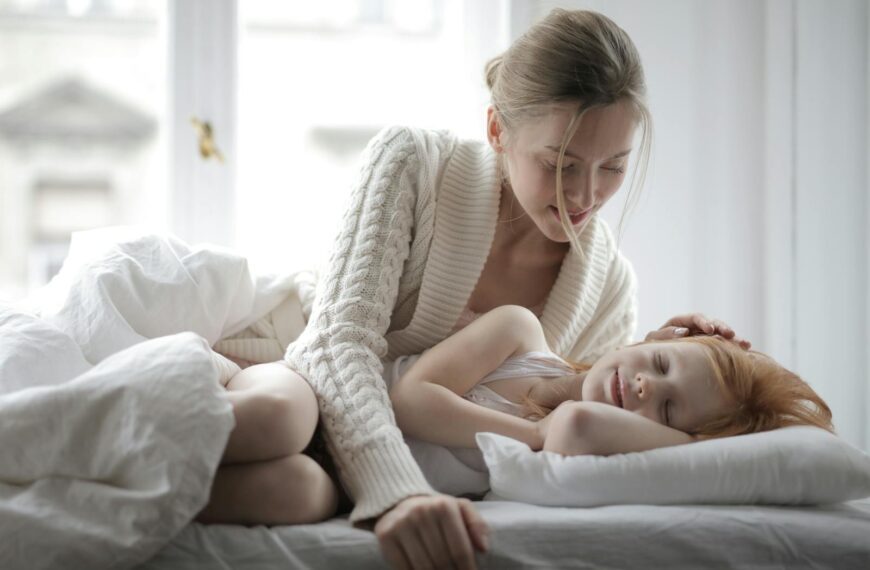 A mother lovingly watches her sleeping child in a cozy bedroom. A moment of warmth and tenderness.