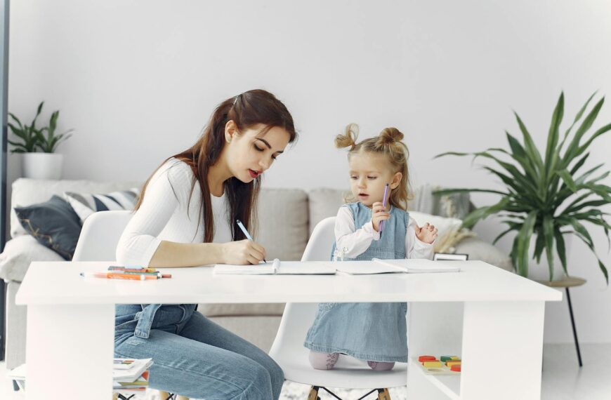 A mother and daughter enjoying a bonding moment while doing homework together at home.
