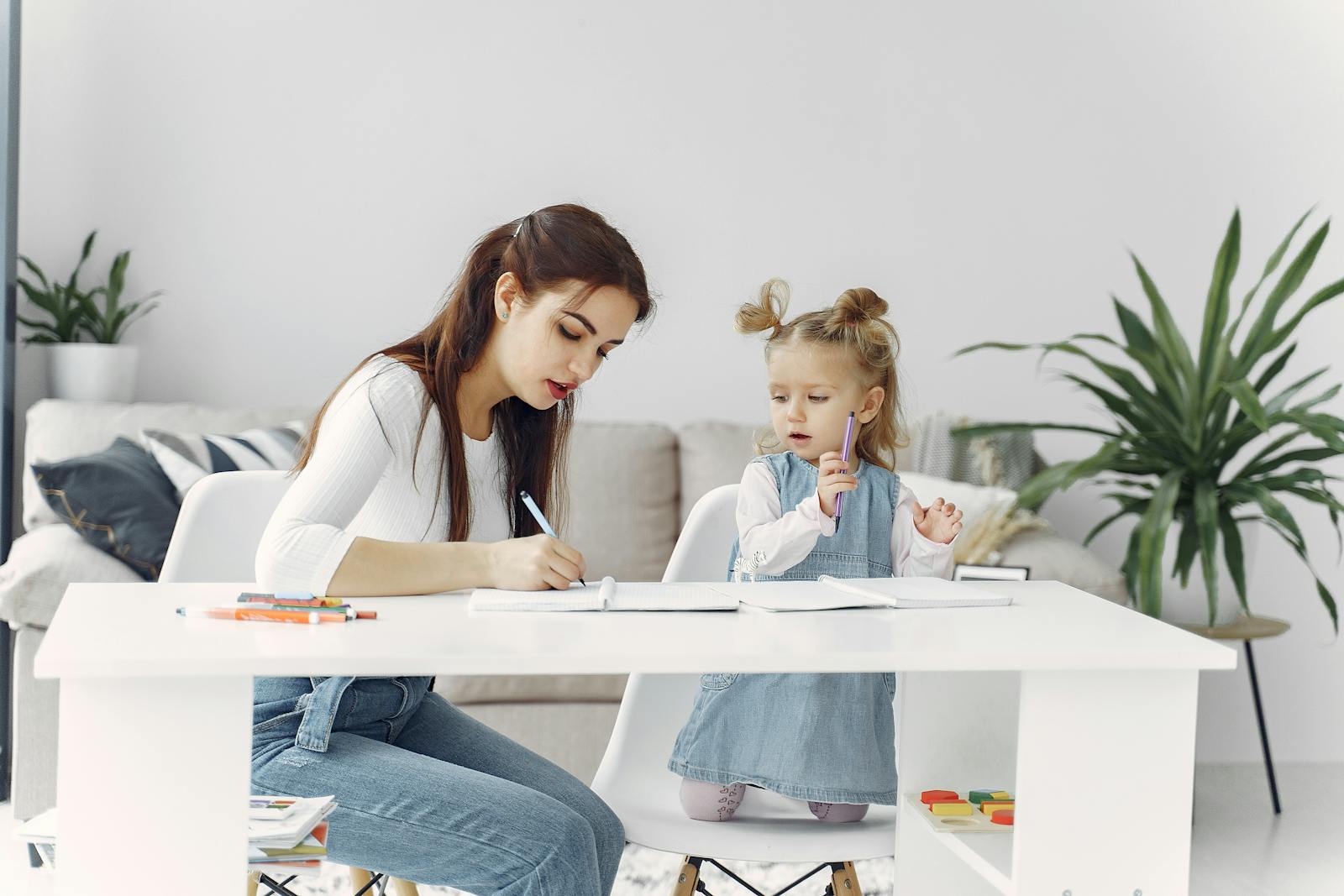 A mother and daughter enjoying a bonding moment while doing homework together at home.