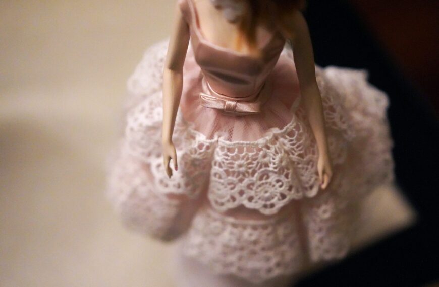 close-up of female doll wearing pink and white dress