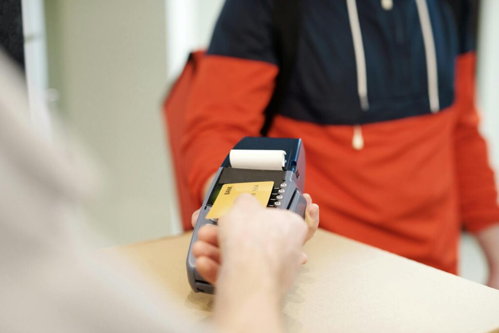 Close-up view of a contactless payment transaction using a credit card on a terminal device.